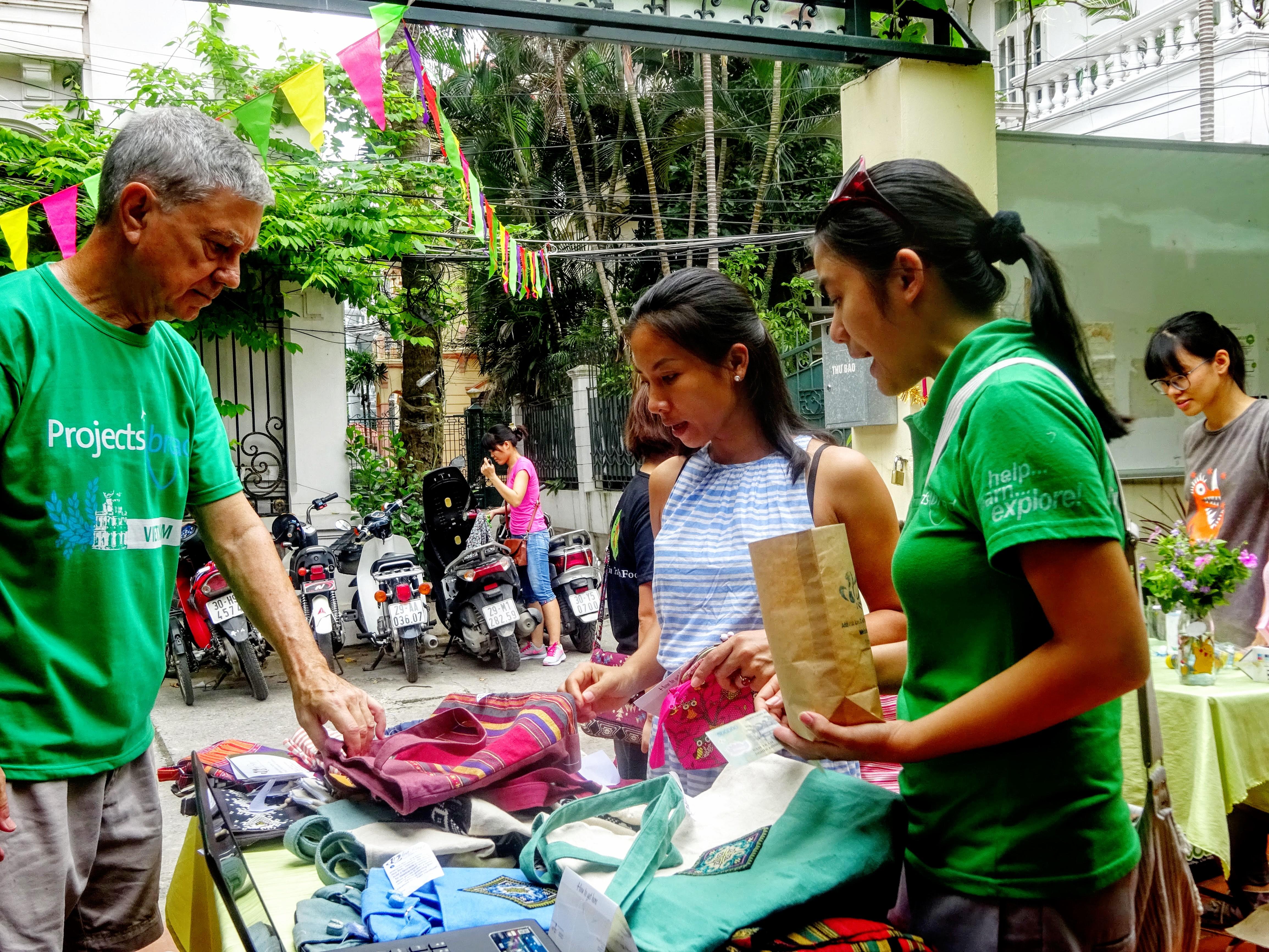 Projects Abroad International Development Interns selling products at a market in Hanoi during their International Development internship in Vietnam. Male and Female International Development Interns sell clothing products at a market during their work placements in Vietnam.